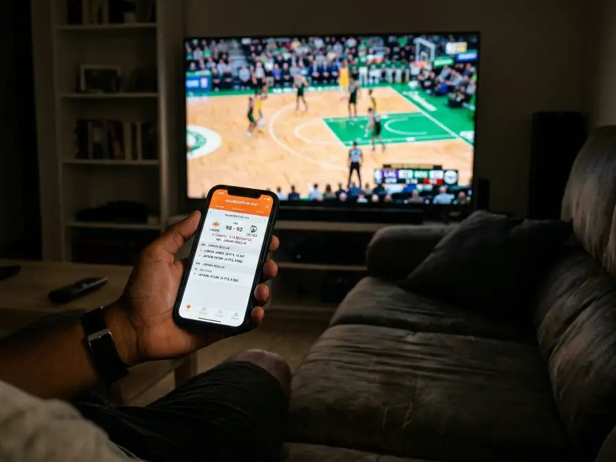 Persona siguiendo un partido de baloncesto NBA en directo desde el teléfono móvil