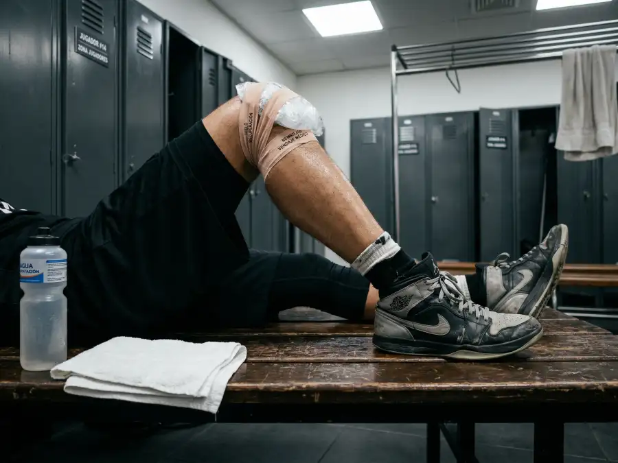 Jugadores de baloncesto NBA en el banquillo durante un descanso mostrando signos de fatiga